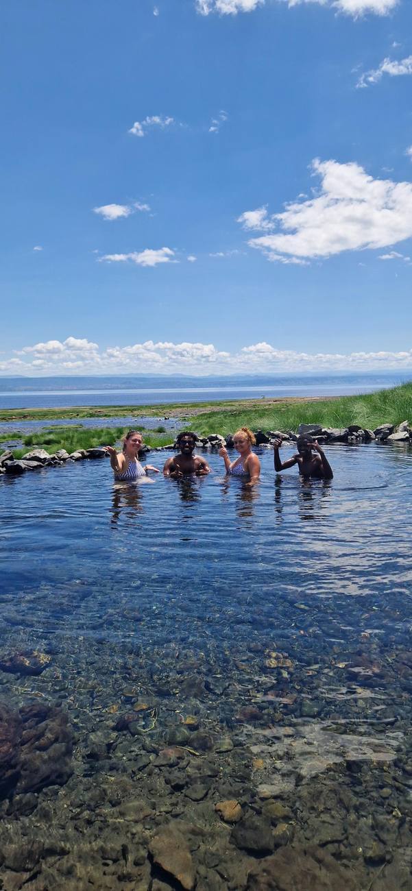 Baignade entre amis dans une source d’eau chaude, face au lac