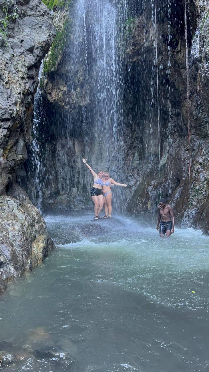 Deux amies sous la cascade d’Engaresero, bras levés