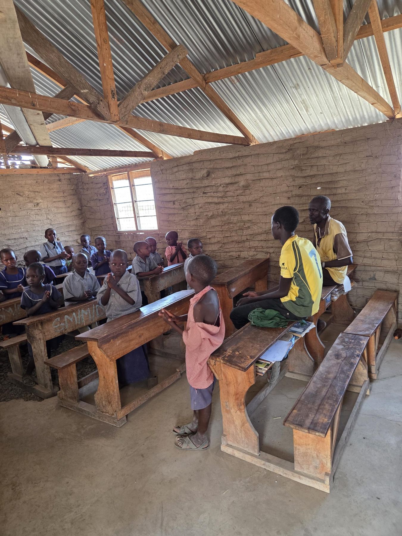 Les élèves en classe, avec deux adultes du village