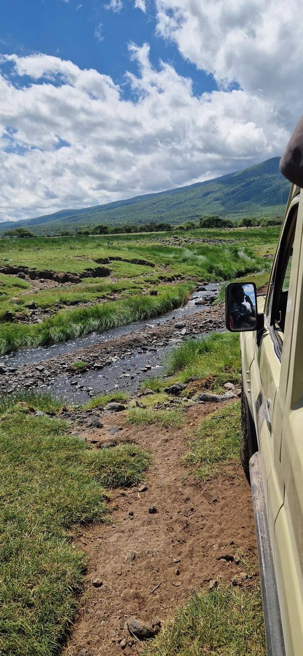 Notre 4x4 sur la piste, au bord d’une rivière, au pied de l’escarpement